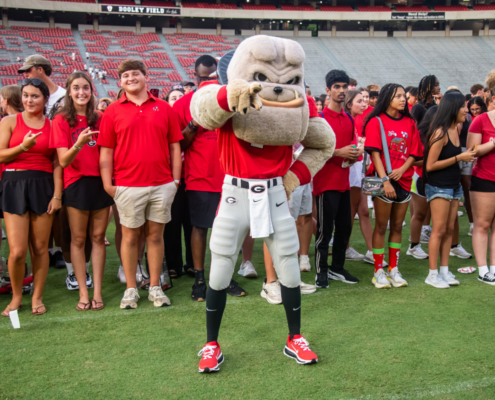 Hairy Dawg poses in front of students from the UGA Class of 2030 on Dooley Field.