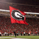 photo of UGA cheerleader running the super G flag onto the football field