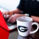 Hands on keyboard with a UGA mug