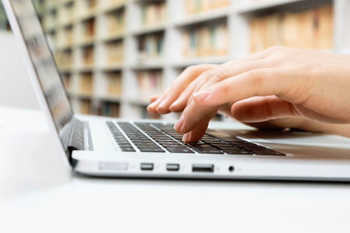 hand typing on a laptop keyboard