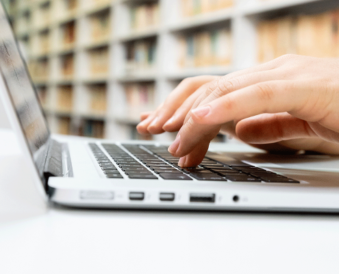 hand typing on a laptop keyboard