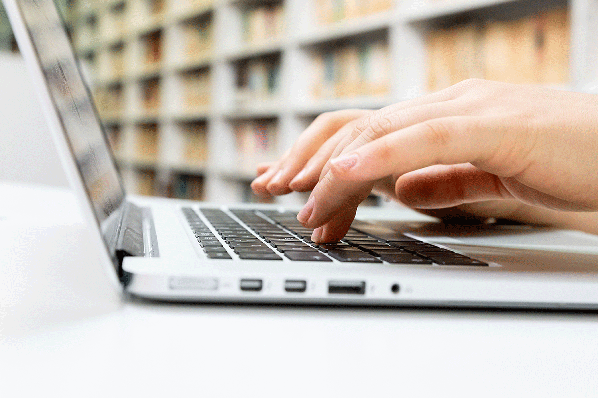 hand typing on a laptop keyboard