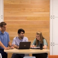 Students talk around a computer